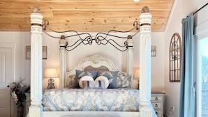 A four-poster bed with a marble headboard, a wooden ceiling fan, and a view of the outdoors through a window. - French Country Retreat Near Ball Ground Weddings, girls getaway. Quiet retreat!  (Ball Ground)
