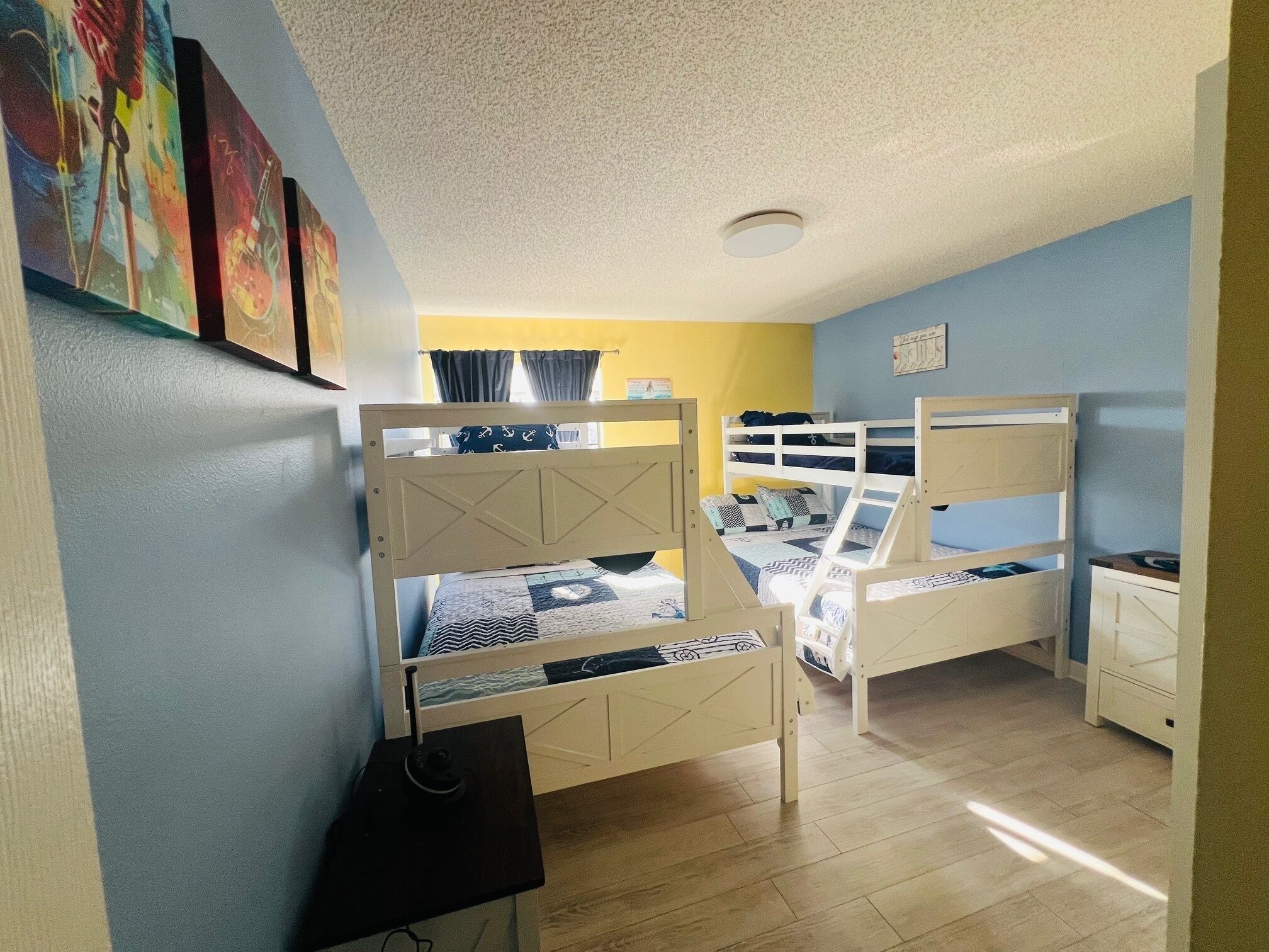 Une chambre avec des lits superposés, un bureau et une chaise.