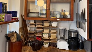 A kitchen with wooden cabinets, a coffee maker, and various kitchen utensils.