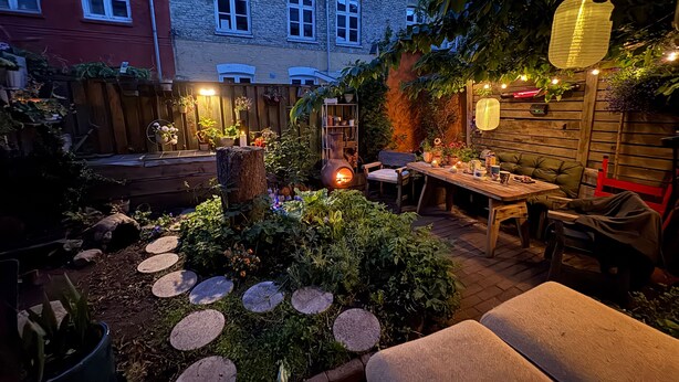 A cozy outdoor seating area with a table, chairs, and a fire pit.