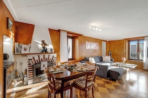 Una sala de estar moderna con chimenea, comedor y sofá.