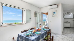 Comedor con vistas al mar, cocina y balcón.