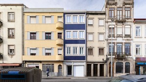 Une rangée d’immeubles à étages, présentant différents styles architecturaux, dont un avec une façade bleue et un autre avec une façade beige.