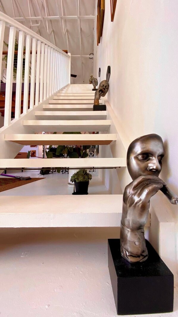 Eine Treppe mit weißen Geländern und einer Skulptur auf der rechten Seite.