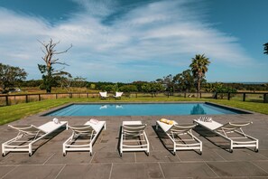 A swimming pool with six white lounge chairs and a palm tree in the background. - The Shearers Quarters at Historic Soho Estate  (Drysdale)