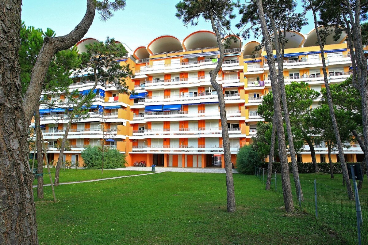 Un hôtel à plusieurs étages, doté de balcons, d’une cour verdoyante et d’arbres.