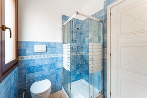 A bathroom with a glass-enclosed shower, a toilet, and a door. - Apartments With Shared Pool, Vignola/mare Aglientu (Aglientu)