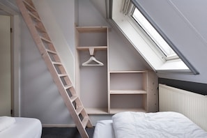 A bedroom with a skylight, a wooden ladder, and built-in shelving. - Skip Wellness De Luxe With Sauna (Earnewald)