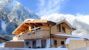 A wooden chalet with a balcony, set against a snowy mountain backdrop. - Apartment In Leutasch With Garden (Leutasch)