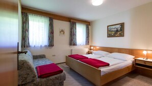 A bedroom with a single bed, a sofa, and a nightstand. - Holiday Flats in St. Georgen am Kreischberg (Sankt Georgen am Kreischberg)