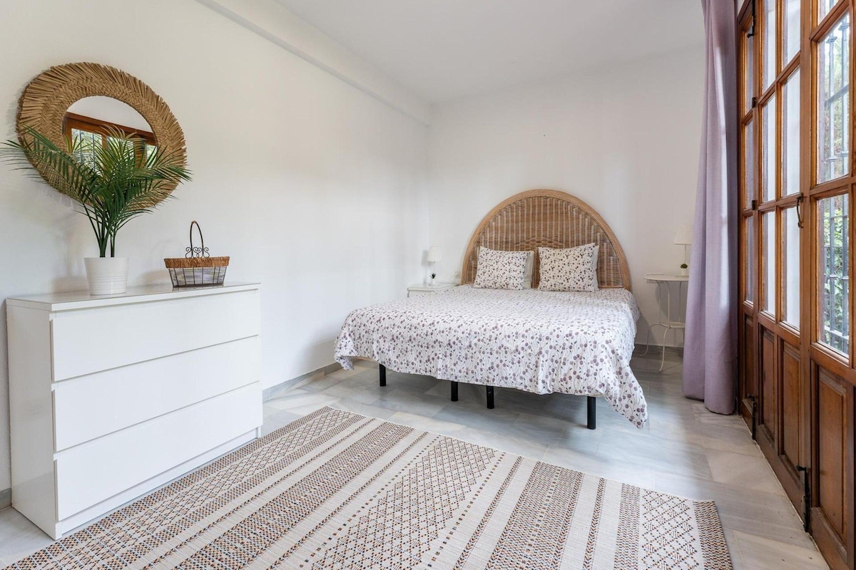 Ein Schlafzimmer mit einem Bett, einem Schminktisch, einem Spiegel und einem Fenster.