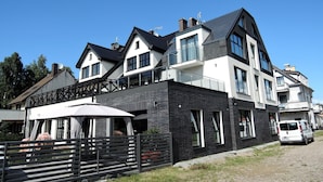 Een modern huis met twee verdiepingen, een balkon, grote ramen en een schotelantenne.