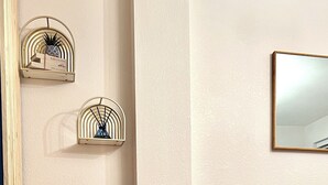 Una sala moderna con un sofá de cuero marrón, una mesita de madera con una planta y un espejo montado en la pared.