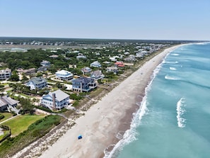 A coastal residential area with houses, a beach, and ocean views.