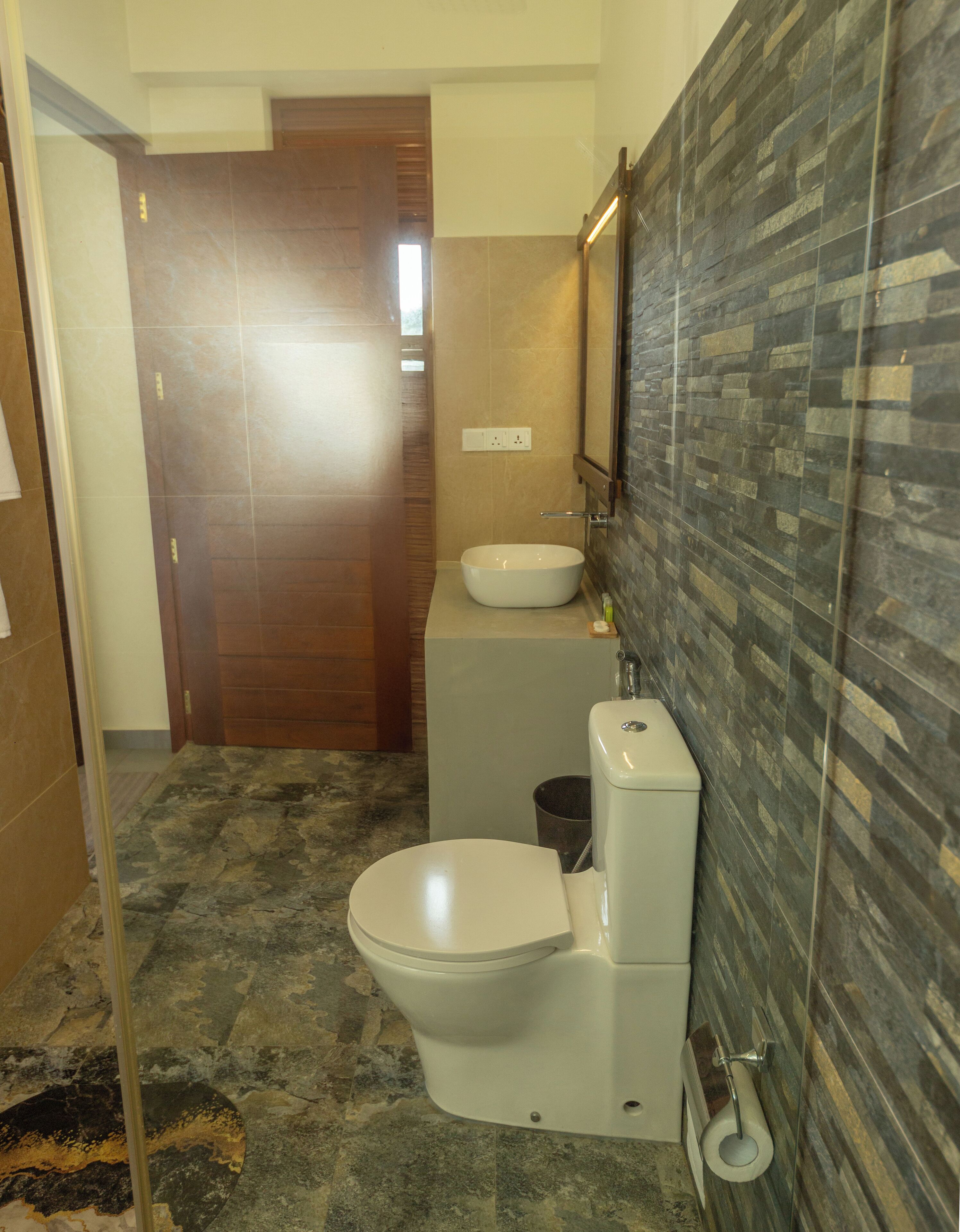 A bathroom with a toilet, sink, and shower area.