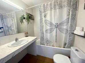 Een badkamer met een witte wastafel, spiegel en toilet.