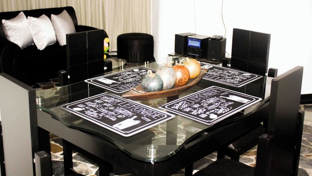 A dining table with black placemats featuring text and a decorative centerpiece. - Cozy apartment in downtown Pereira (Pereira)