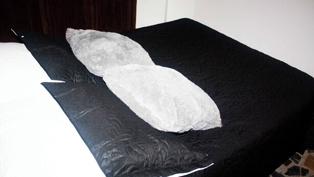 Una cama con un colchón negro y una almohada blanca.