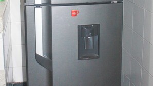 A stainless steel refrigerator with a water dispenser, placed in a tiled kitchen area. - Cozy apartment in downtown Pereira (Pereira)