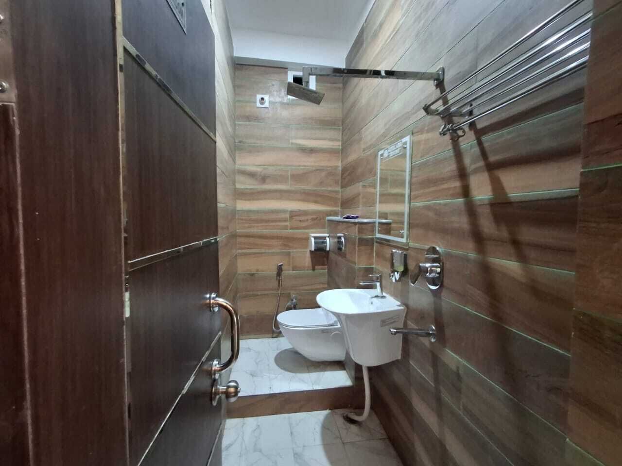 Un baño pequeño con diseño moderno, que incluye inodoro, lavabo y cabina de ducha de vidrio.