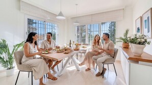 Un coin repas avec une grande table, des chaises et une plante en pot.
