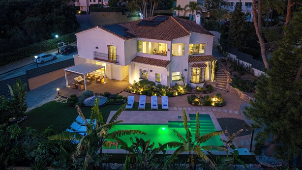 Une maison à deux étages dotée d’un patio, d’une piscine et d’un jardin bien entretenu.