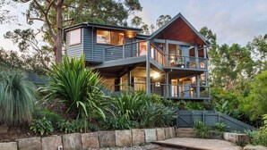A two-story house with a balcony, surrounded by lush greenery and a swimming pool. - Cosy Mountain house w/fire and pool on Tamborine Mountain! (Tamborine Mountain)