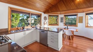 A modern kitchen with wooden ceiling, large windows, and a central island. - Cosy Mountain house w/fire and pool on Tamborine Mountain! (Tamborine Mountain)