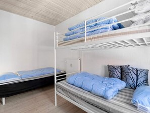A bunk bed room with a white ceiling and a radiator.