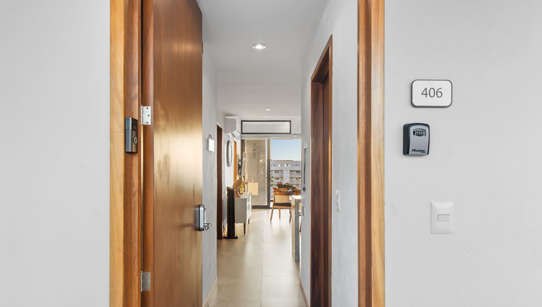 A hotel hallway with a wooden door, a number sign, and a Master keypad.