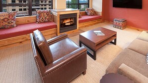 A cozy living room with a fireplace, leather sofa, and a flat-screen TV.