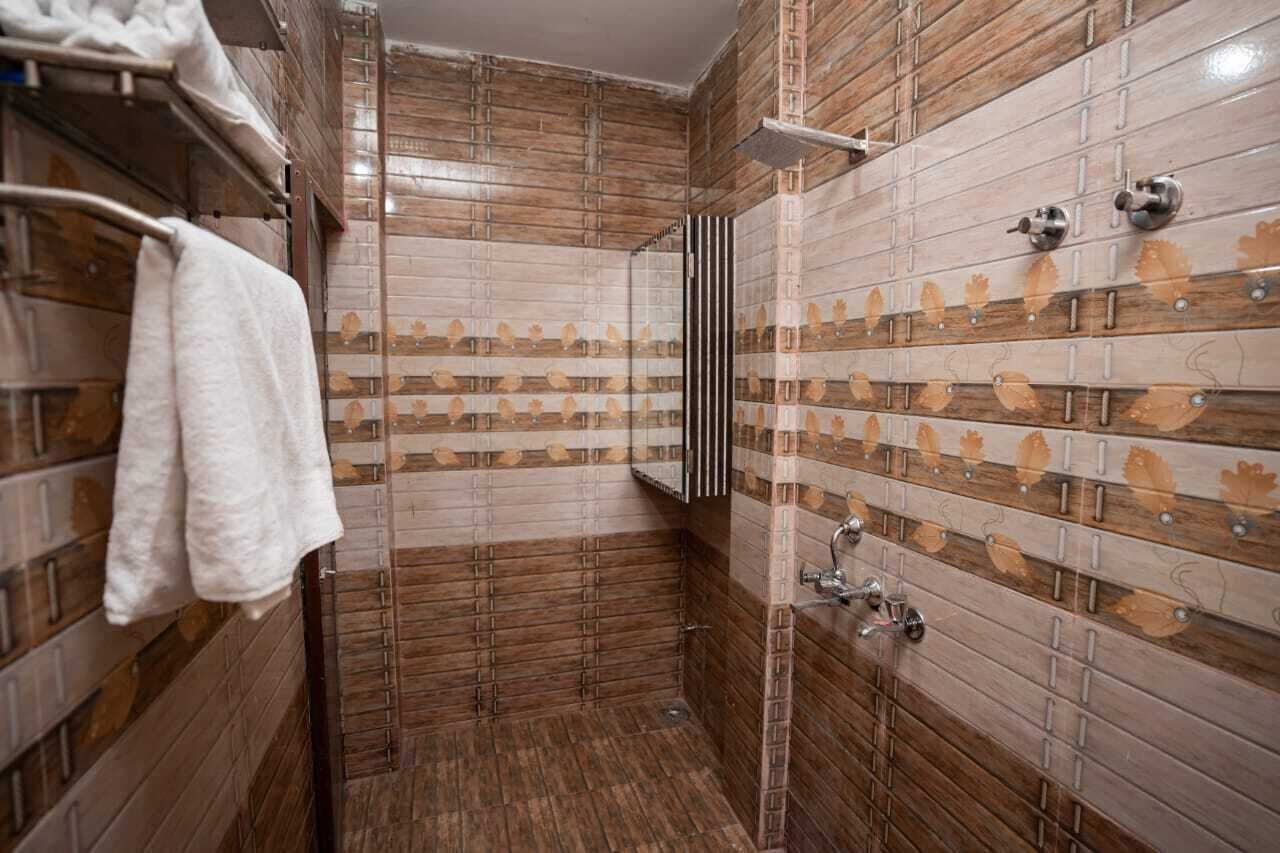 A bathroom with wooden paneling and a tiled shower area.