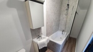 Une salle de bain avec des toilettes, un lavabo et une baignoire.