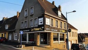 Un immeuble sur lequel on peut voir une enseigne indiquant le restaurant et l’hôtel « Le Flibert ».