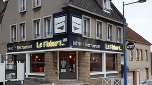 Un hôtel à la façade noire et blanche, doté de grandes fenêtres et d’une entrée bien visible.