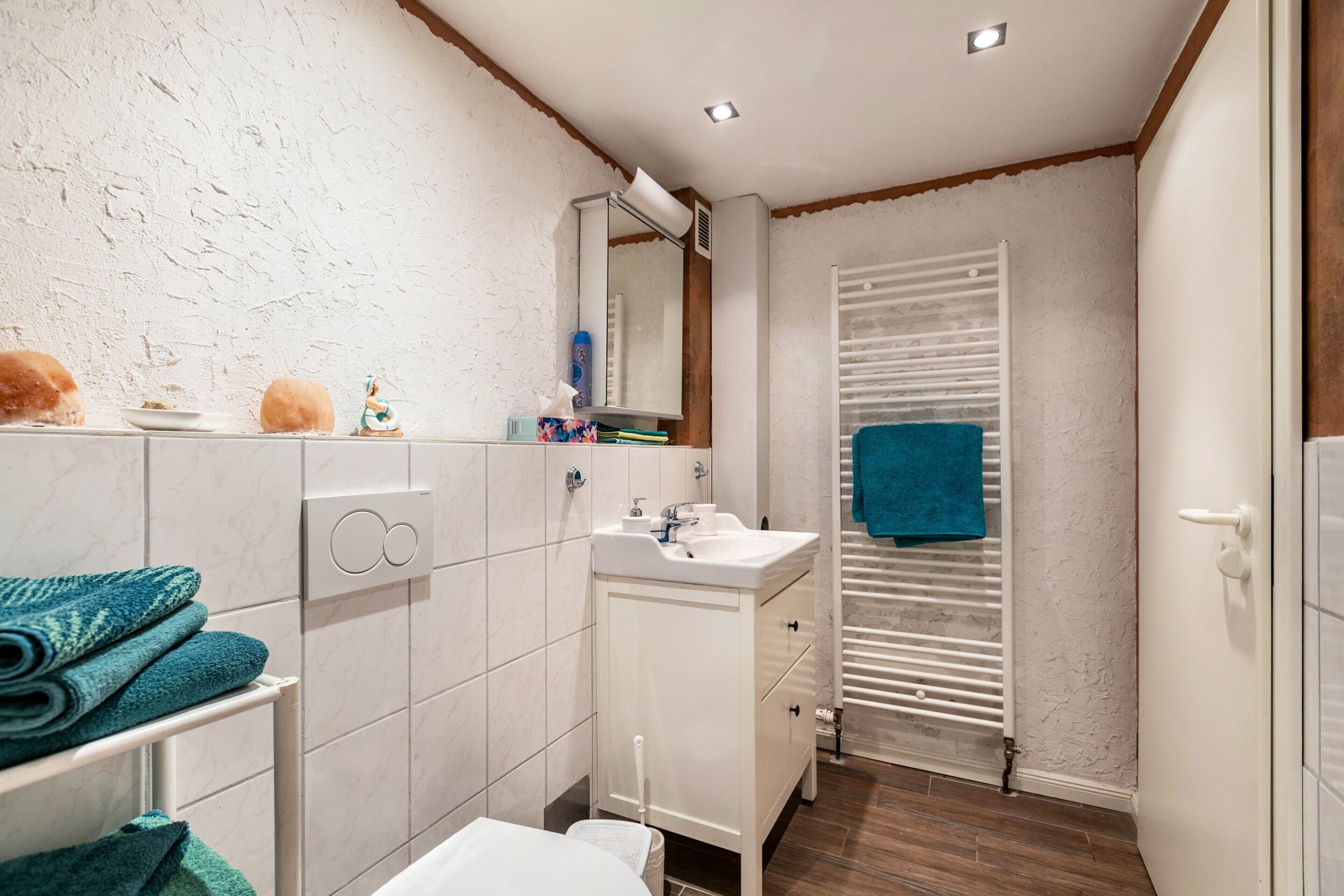 Ein Badezimmer mit weißem Waschbecken, Spiegel und Handtuchhalter.