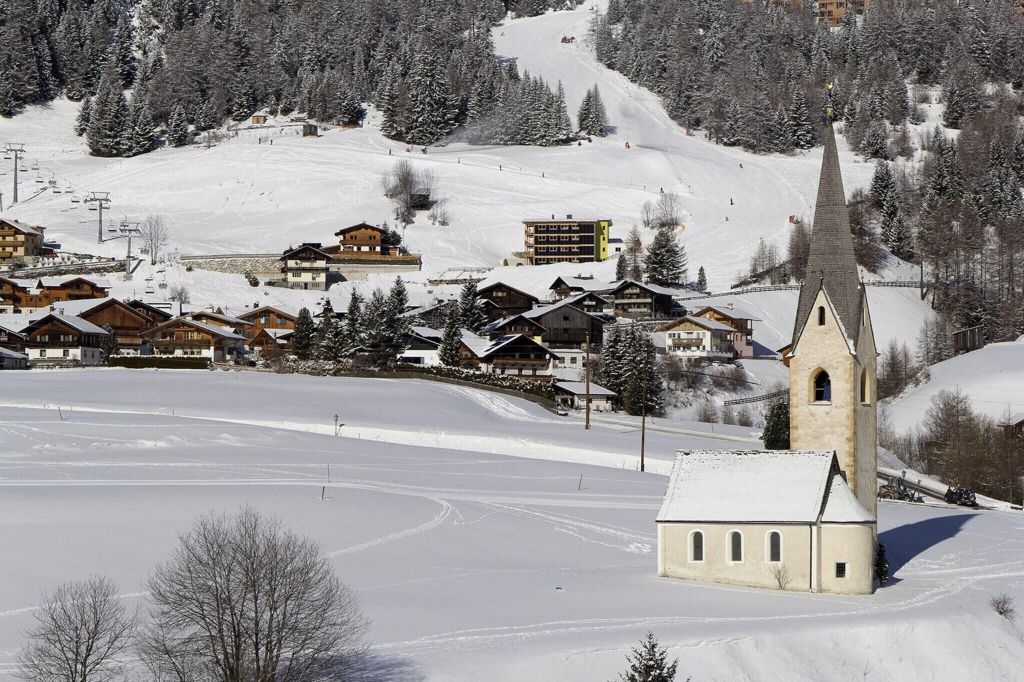 A snow-covered village with wooden buildings and a church.