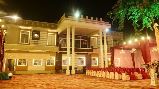 Un edificio a più piani con una zona esterna coperta, colonne e un palco con sedie.