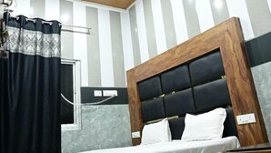 Camera da letto con struttura letto in legno, ventilatore a soffitto e decorazione murale a righe.