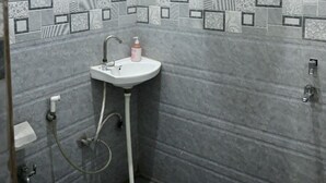 Un bagno con un lavandino bianco, un water e uno scaldabagno a parete.