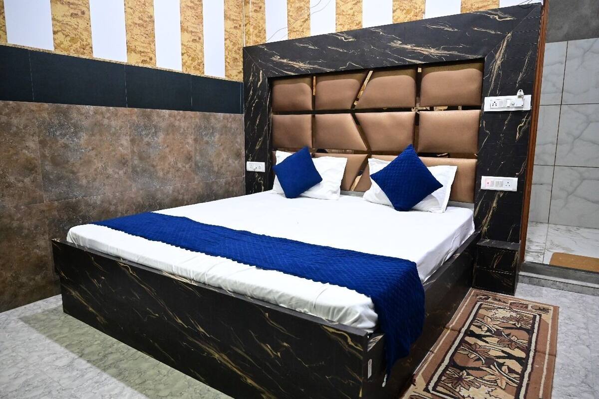 A bed with a black headboard, white bedding, and blue accents.