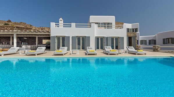 Relax by the pool surrounded by lounge chairs and sunbeds.