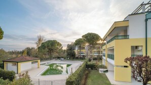 A modern building with a courtyard, a small pool, and well-maintained greenery.