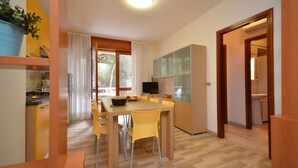 Cocina compacta con comedor, televisor y un amplio ventanal.