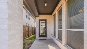 A narrow concrete pathway leading to a door with a small step. - Cozy Home Luxury Corporate Housing (Lewisville)