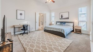 A bedroom with a bed, desk, chair, and a ceiling fan. - Cozy Home Luxury Corporate Housing (Lewisville)