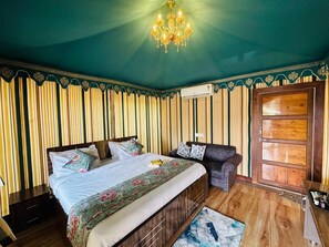 Une chambre à coucher avec un lit, un canapé, une porte en bois et un lustre.