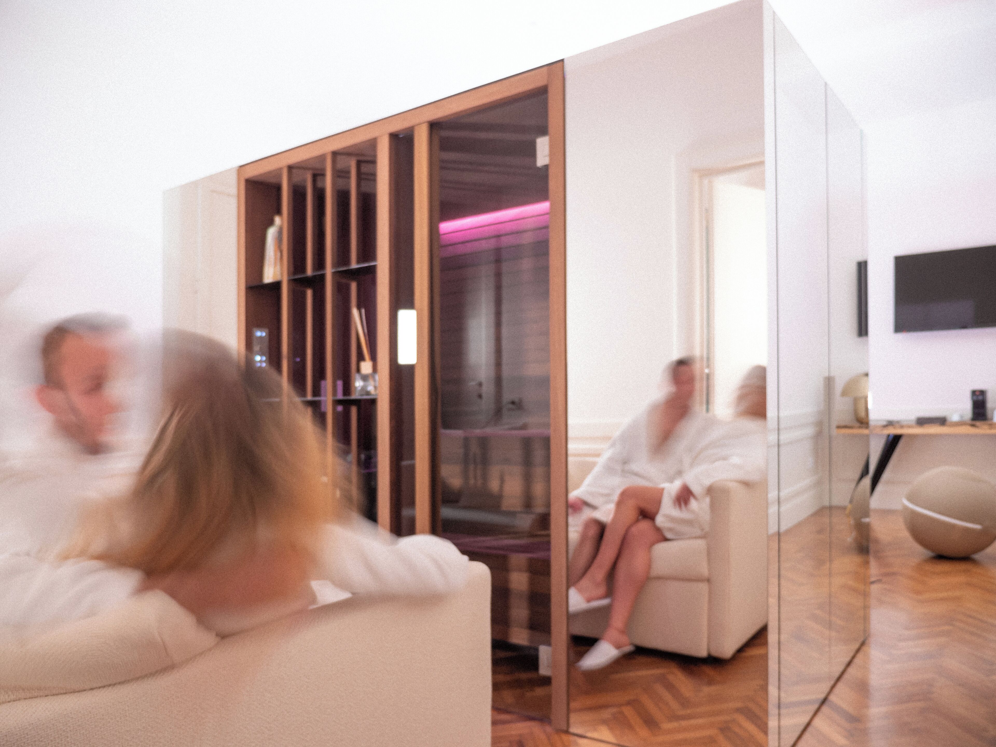 A modern interior with a glass partition, a sofa, and a television.