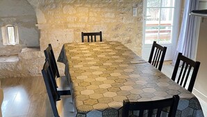 Un espace repas avec une table à motifs hexagonaux, des chaises noires et un luminaire suspendu.