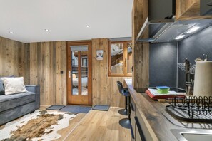 Una cocina moderna con detalles de madera, una barra y una zona de estar acogedora con alfombra de cuero de vaca.